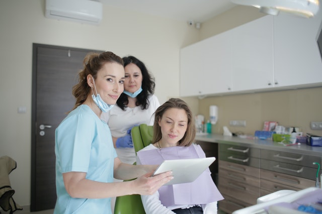 cheerful stomatologist and assistant showing medical report 3952125